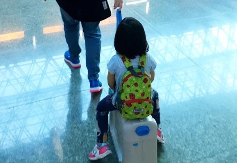 kid on rolling luggage