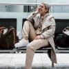 trendy woman on bench at airport